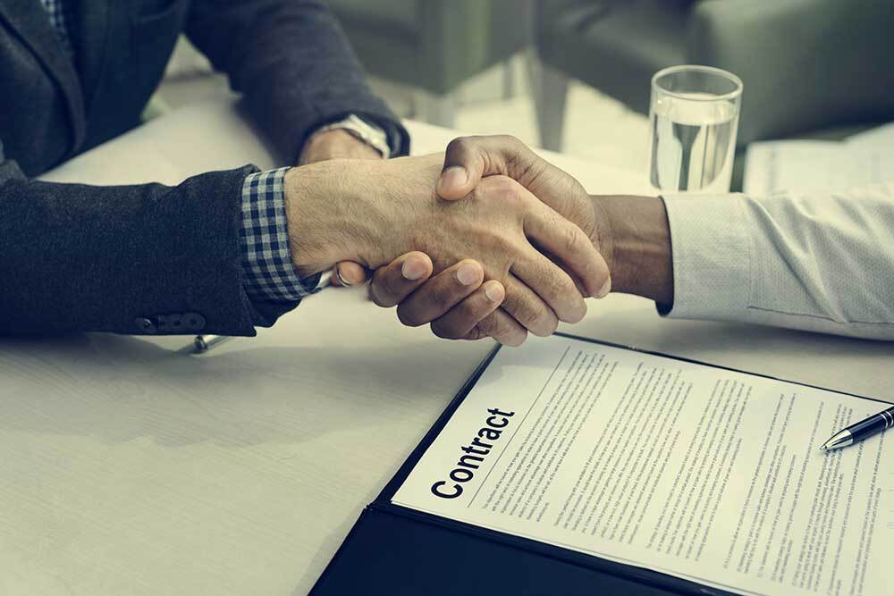 Professionals shaking hands after signing a contract