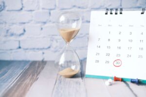 Hourglass and a calendar depicting fast approaching deadline